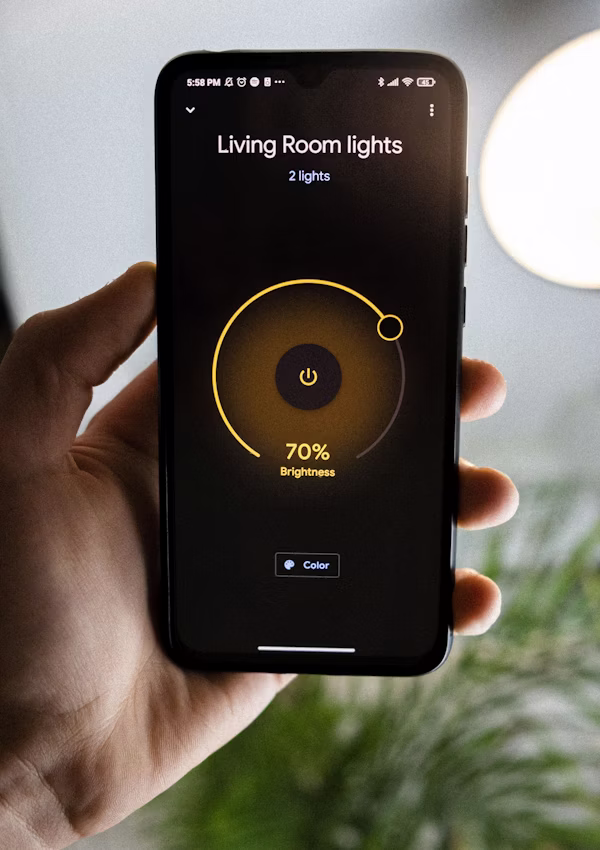 Smartphone pilotant l'éclairage d'un salon connecté